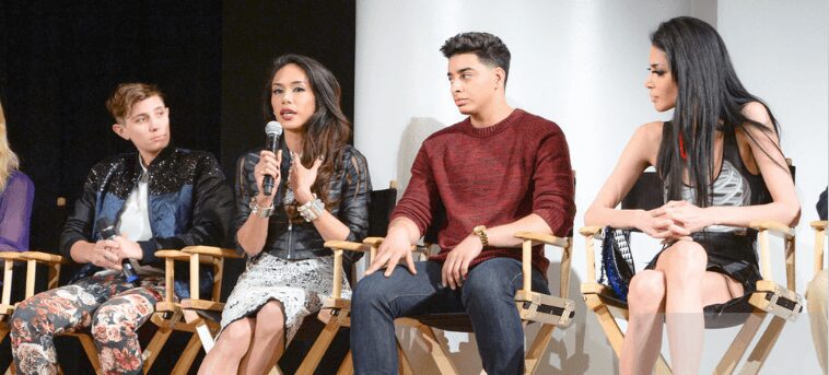 Two people engaged in a panel discussion, one speaking into a microphone.
