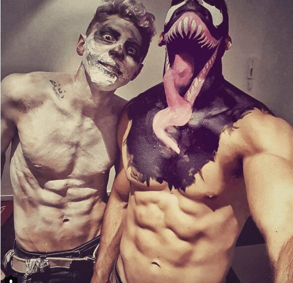 Two muscular men in creative, spooky body paint costumes.