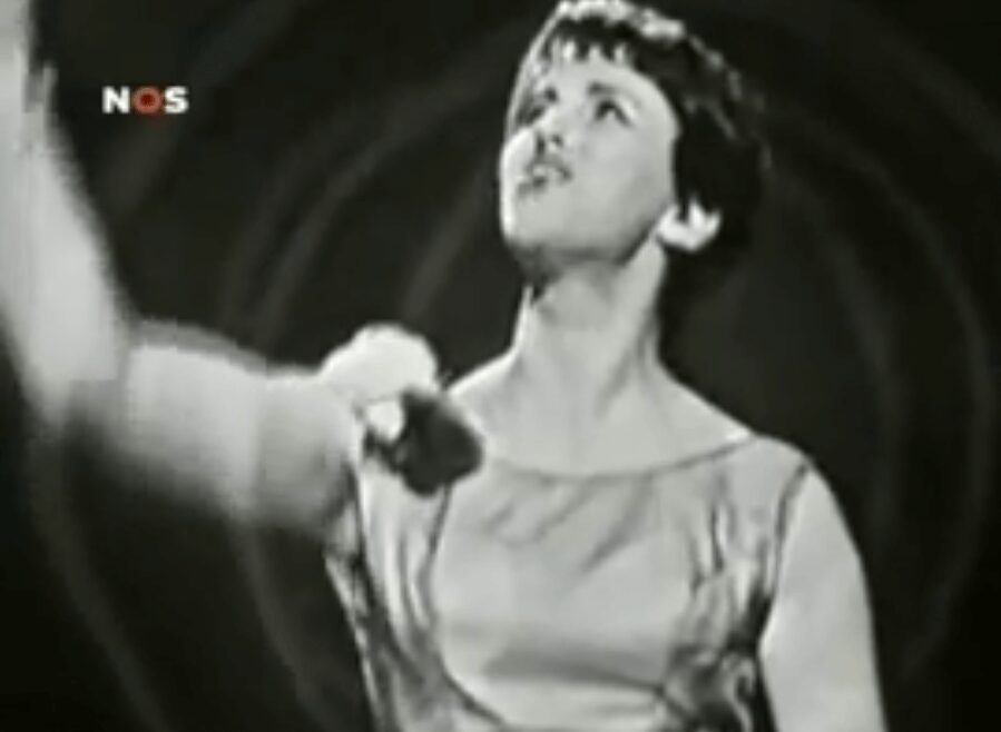 Black and white image of a woman singing passionately.