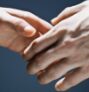 Two hands gently holding each other in a tender gesture.