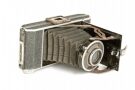 Vintage folding camera with bellows and metal lens.