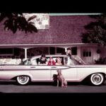 Vintage car parked in front of house.
