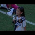 Young girl speaking on soccer field.