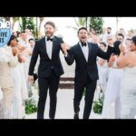 Two grooms celebrating at their wedding ceremony.