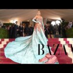 Woman in elegant gown on red carpet.