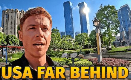 Man in front of modern skyscrapers and green park on a sunny day.