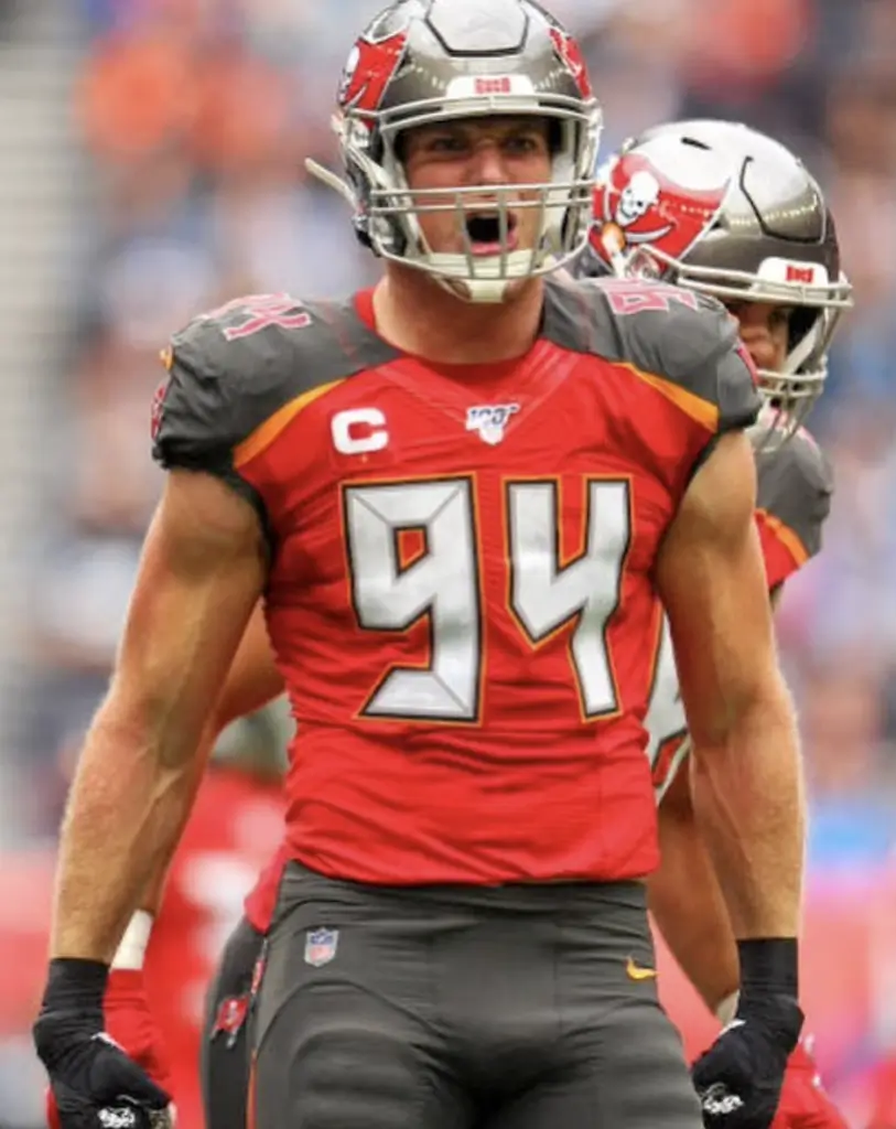 NFL player in red Tampa Bay Buccaneers jersey shouting on field.